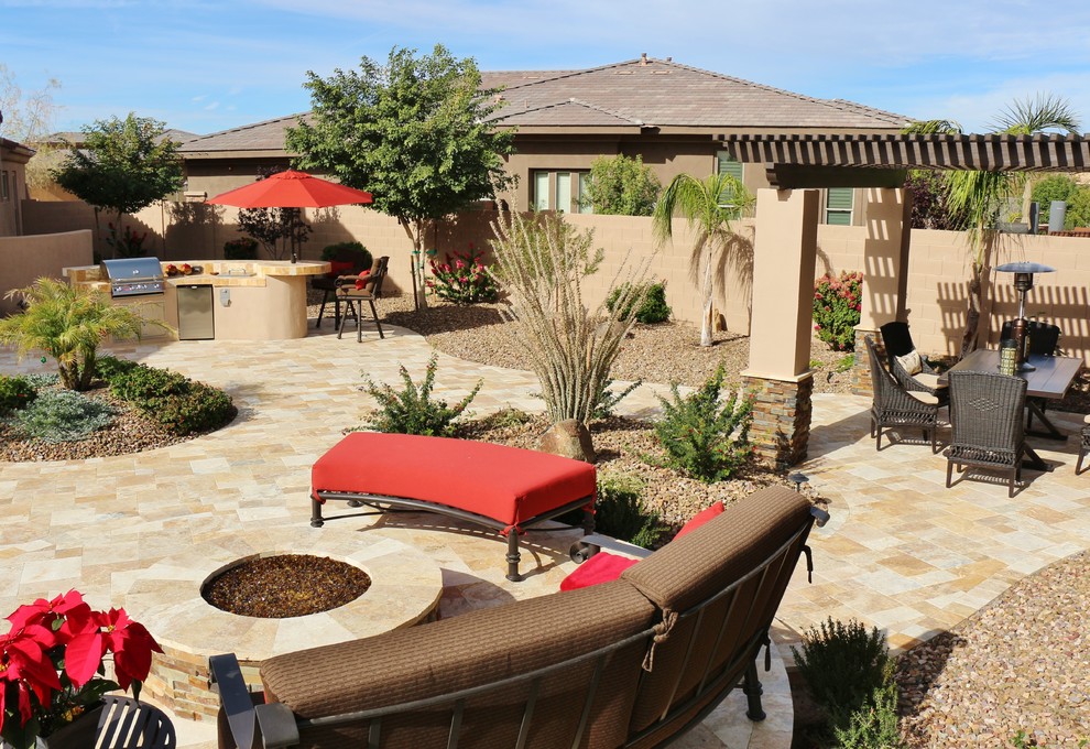 This is an example of a mid-sized contemporary backyard patio in Phoenix with natural stone pavers.