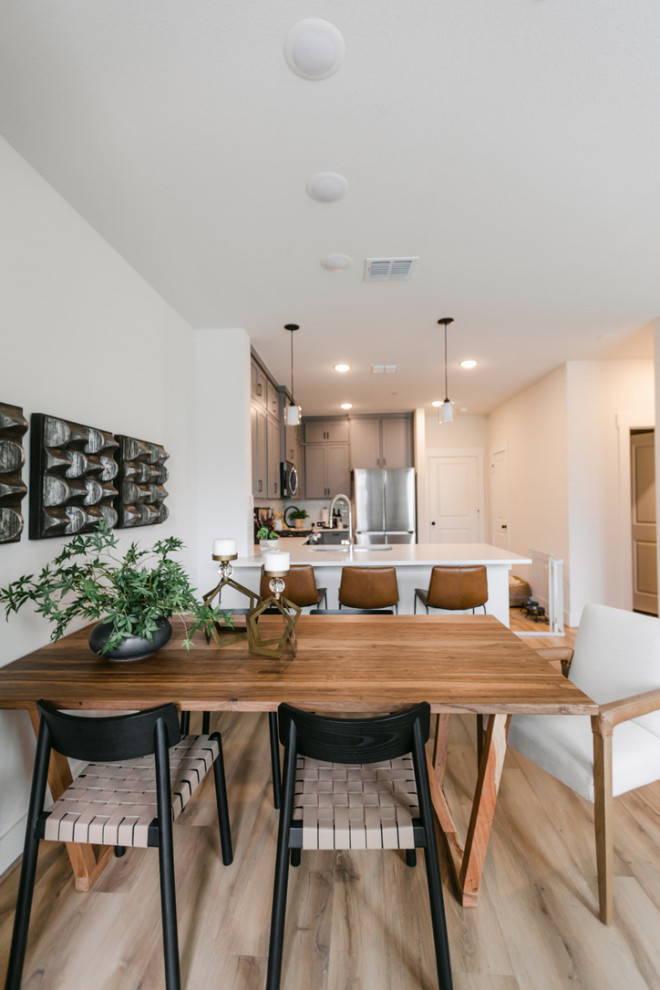 Idée de décoration pour une petite salle à manger minimaliste avec un mur blanc, sol en stratifié, aucune cheminée et un sol marron.