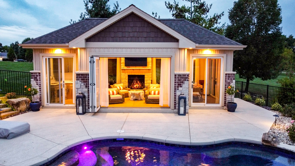 Design ideas for a large backyard pool in St Louis with a pool house and stamped concrete.