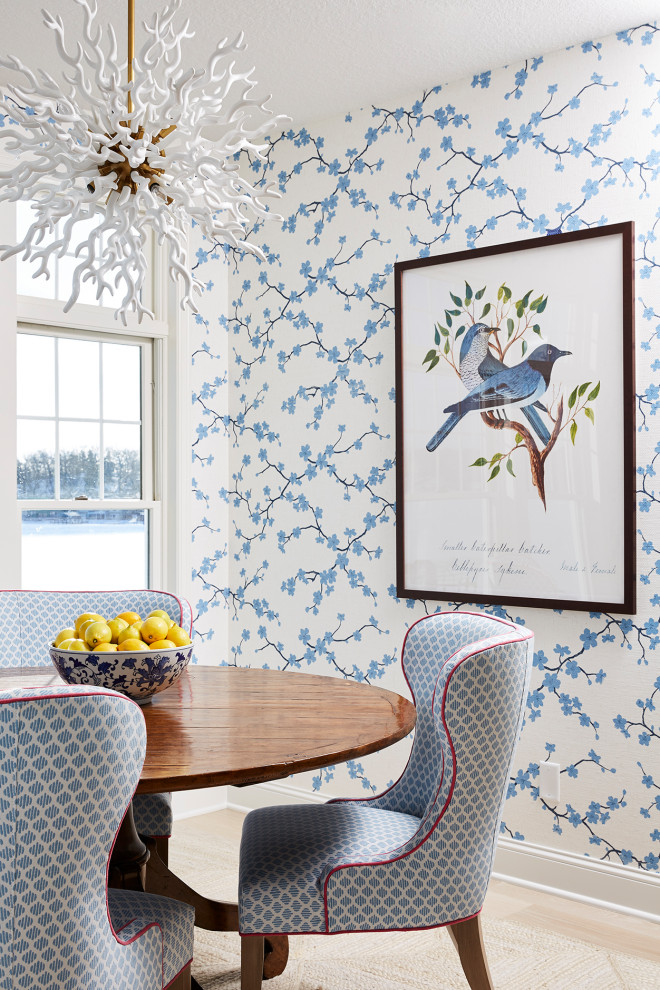 Immagine di una sala da pranzo aperta verso la cucina di medie dimensioni con pareti blu e parquet chiaro