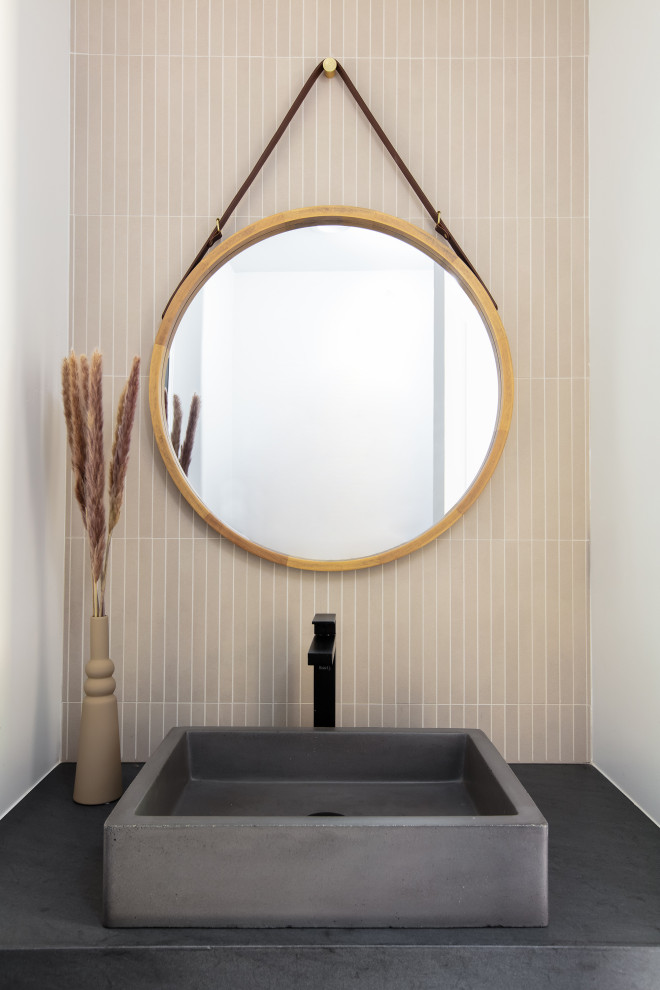 Idée de décoration pour un WC et toilettes minimaliste avec un carrelage beige, un mur blanc, une vasque, un plan de toilette en quartz modifié et un plan de toilette noir.