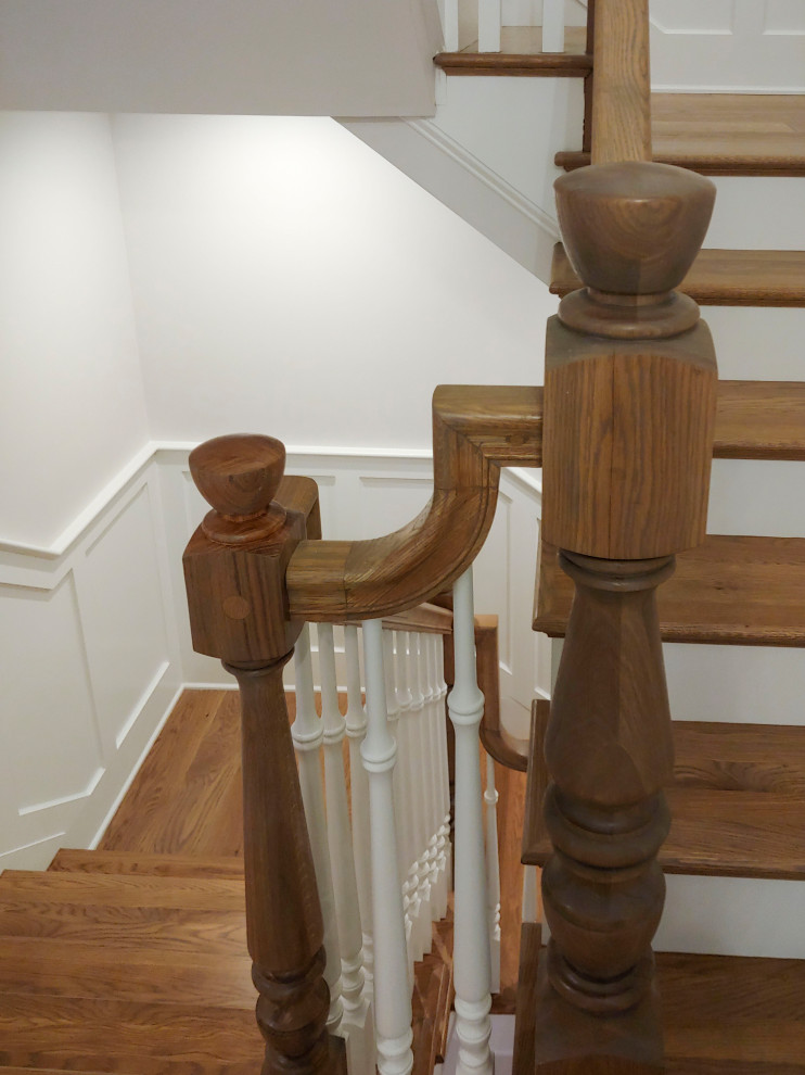 Photo of a mid-sized traditional wood u-shaped staircase in DC Metro with painted wood risers, wood railing and decorative wall panelling.