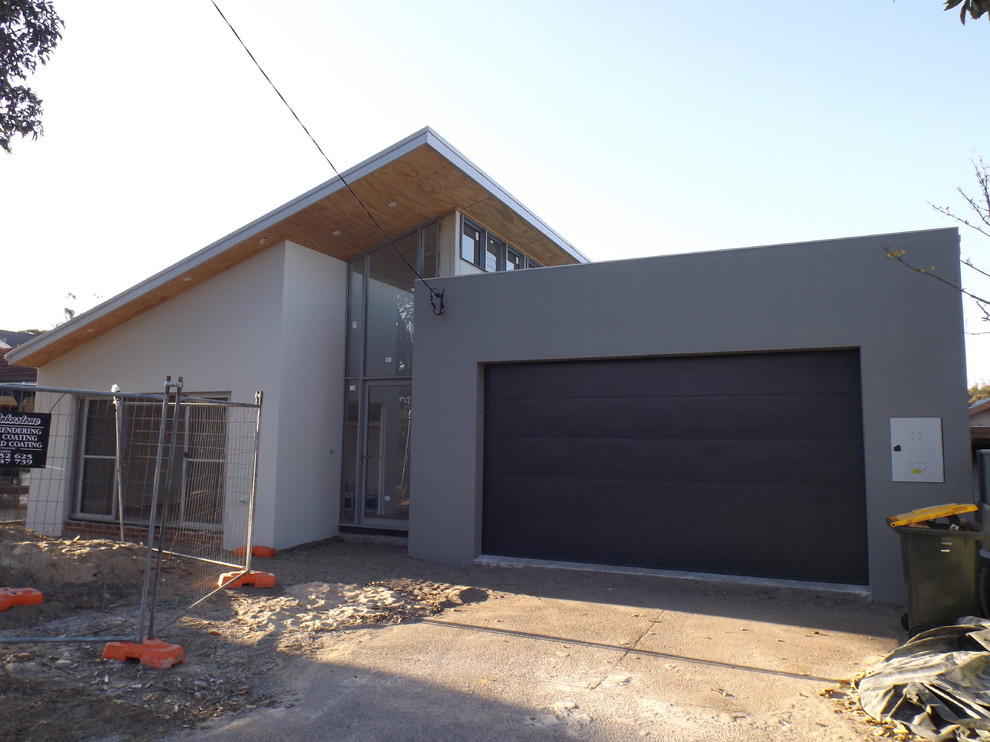 This is an example of a large modern one-storey brick grey house exterior in Central Coast with a shed roof and a metal roof.