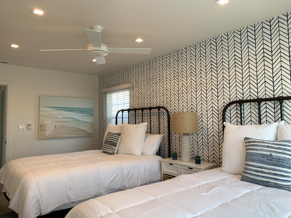 Foto de habitación de invitados costera pequeña con paredes azules, suelo vinílico, suelo beige y papel pintado