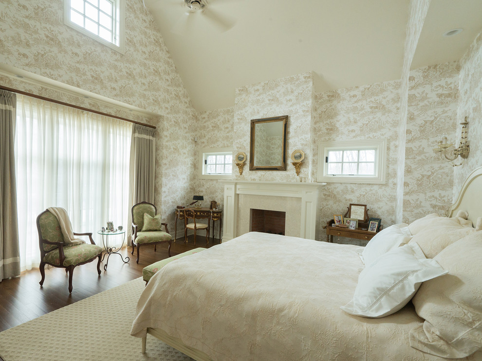 Imagen de dormitorio principal tradicional grande con paredes multicolor, todas las chimeneas, marco de chimenea de madera y suelo de madera en tonos medios