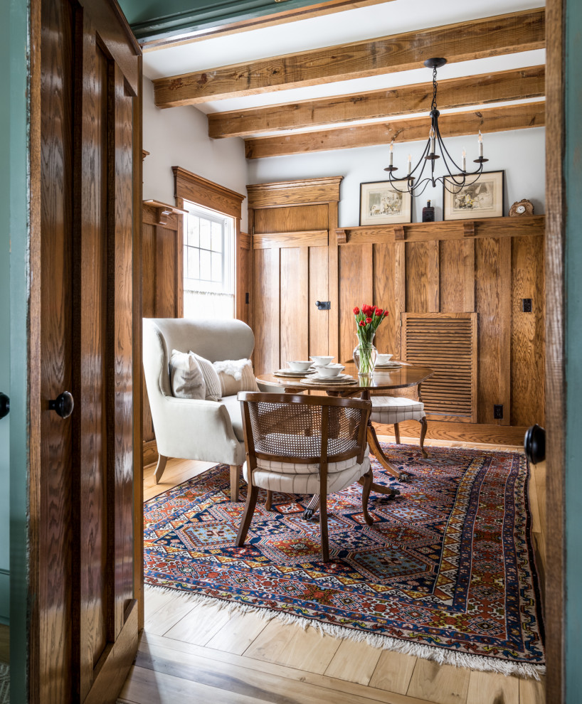 This is an example of a mid-sized country separate dining room in Nashville with blue walls, a standard fireplace, a stone fireplace surround, brown floor, wood and panelled walls.