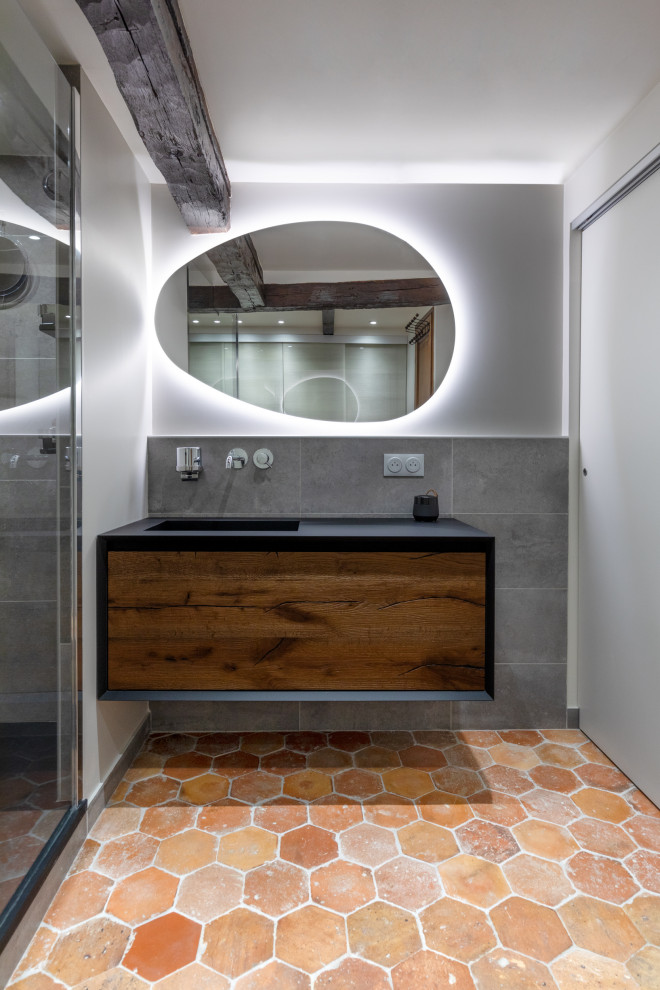 Inspiration for a large contemporary bathroom in Paris with a curbless shower, gray tile, stone tile, terra-cotta floors, an undermount sink, marble benchtops, a hinged shower door, black benchtops, a laundry, a single vanity and a built-in vanity.