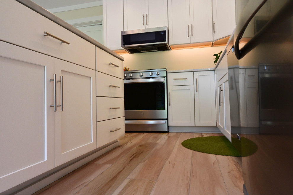Example of a small transitional l-shaped light wood floor open concept kitchen design with an undermount sink, shaker cabinets, white cabinets, quartz countertops, an island and white countertops