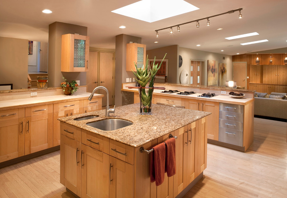 Inspiration for a large traditional u-shaped open plan kitchen in Milwaukee with an undermount sink, shaker cabinets, light wood cabinets, granite benchtops, stainless steel appliances, light hardwood floors, with island and beige floor.