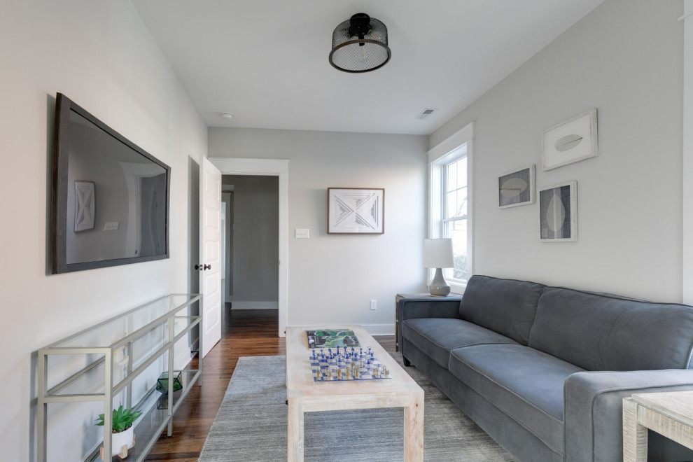 Источник вдохновения для домашнего уюта: изолированная гостиная комната среднего размера в классическом стиле с серыми стенами, паркетным полом среднего тона, телевизором на стене и коричневым полом