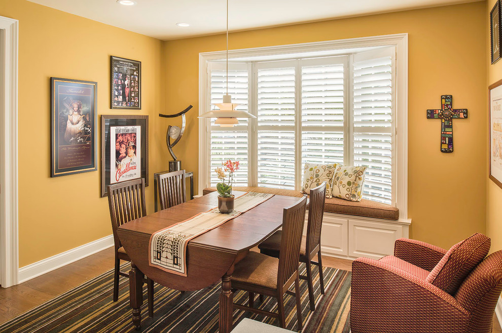 Photo of a mid-sized contemporary separate dining room in Cleveland with yellow walls, medium hardwood floors and no fireplace.