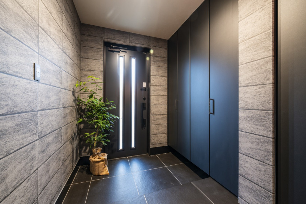 Entryway - mid-sized modern ceramic tile, black floor, wallpaper ceiling and wallpaper entryway idea in Other with black walls and a black front door