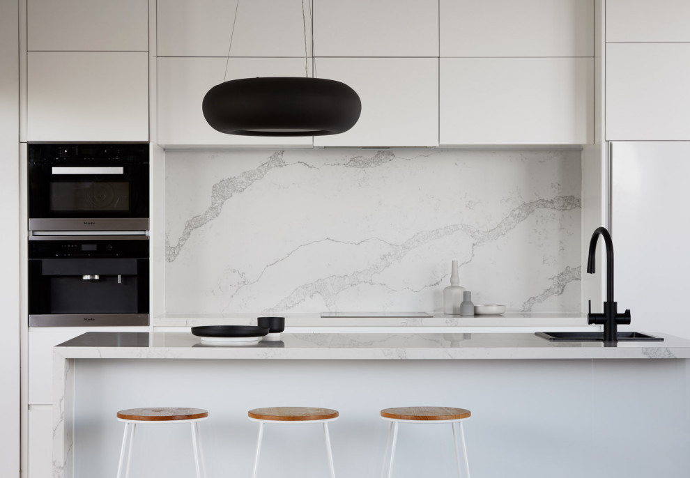 Design ideas for a mid-sized contemporary galley eat-in kitchen in Melbourne with a single-bowl sink, open cabinets, white cabinets, marble benchtops, white splashback, marble splashback, black appliances, with island and white benchtop.