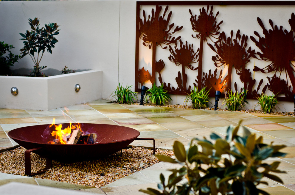 Mid-sized modern backyard full sun garden in Other with a fire feature and brick pavers for summer.