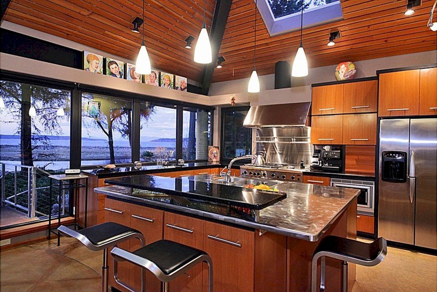 Inspiration for a large industrial l-shaped kitchen in Seattle with a double-bowl sink, flat-panel cabinets, medium wood cabinets, stainless steel benchtops and stainless steel appliances.