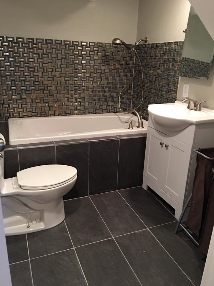 Inspiration for a small transitional 3/4 gray tile and metal tile porcelain tile and gray floor alcove bathtub remodel with shaker cabinets, white cabinets, a two-piece toilet, beige walls, an integrated sink, solid surface countertops and white countertops