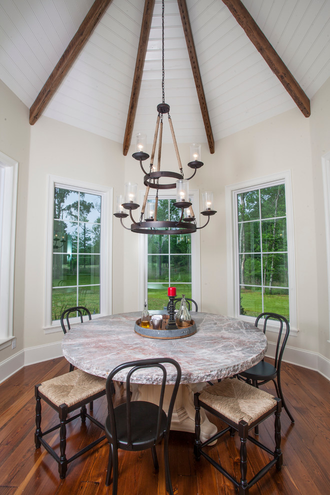 This is an example of a country separate dining room in New Orleans with white walls and medium hardwood floors.