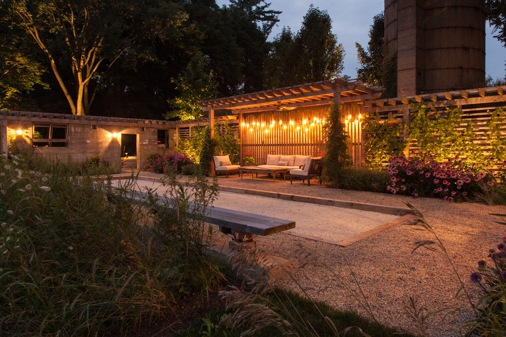Photo of a mid-sized country side yard patio in Chicago with gravel and a pergola.