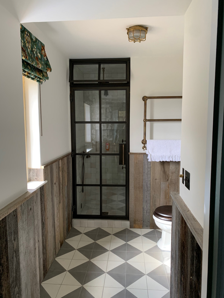 Design ideas for a small rural grey and brown shower room bathroom in Oxfordshire with a built-in shower, a two-piece toilet, white walls, cement flooring, a pedestal sink, multi-coloured floors, a hinged door, a dado rail, a single sink and panelled walls.