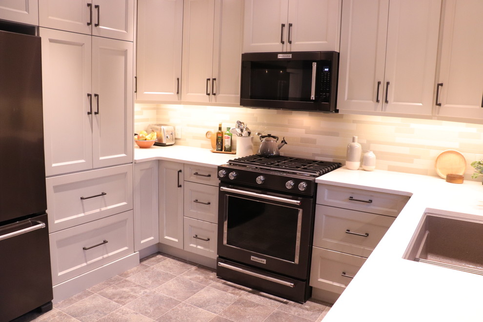 This is an example of a small transitional u-shaped eat-in kitchen in Edmonton with an undermount sink, shaker cabinets, white cabinets, quartz benchtops, beige splashback, ceramic splashback, stainless steel appliances, linoleum floors, with island, beige floor and yellow benchtop.