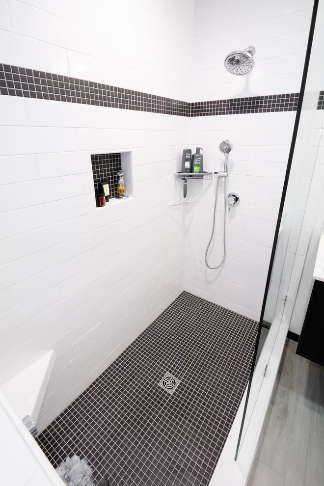 Exemple d'une salle de bain principale tendance de taille moyenne avec un placard à porte plane, des portes de placard noires, une douche ouverte, WC à poser, un carrelage blanc, des carreaux de céramique, un mur blanc, parquet clair, une vasque et un plan de toilette en granite.