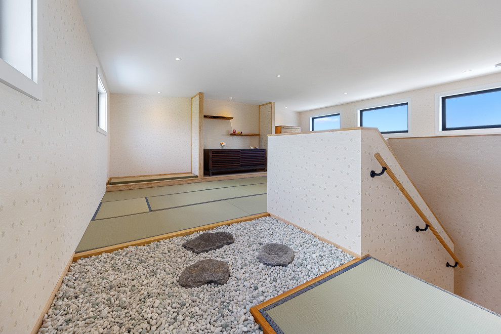 Foto di una camera da letto etnica con pareti bianche, pavimento in tatami e carta da parati