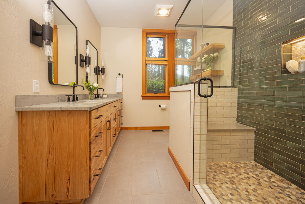 Example of a large mountain style master multicolored tile and ceramic tile porcelain tile, gray floor and double-sink doorless shower design with shaker cabinets, medium tone wood cabinets, a one-piece toilet, beige walls, an undermount sink, quartzite countertops, a hinged shower door, gray countertops, a niche and a floating vanity