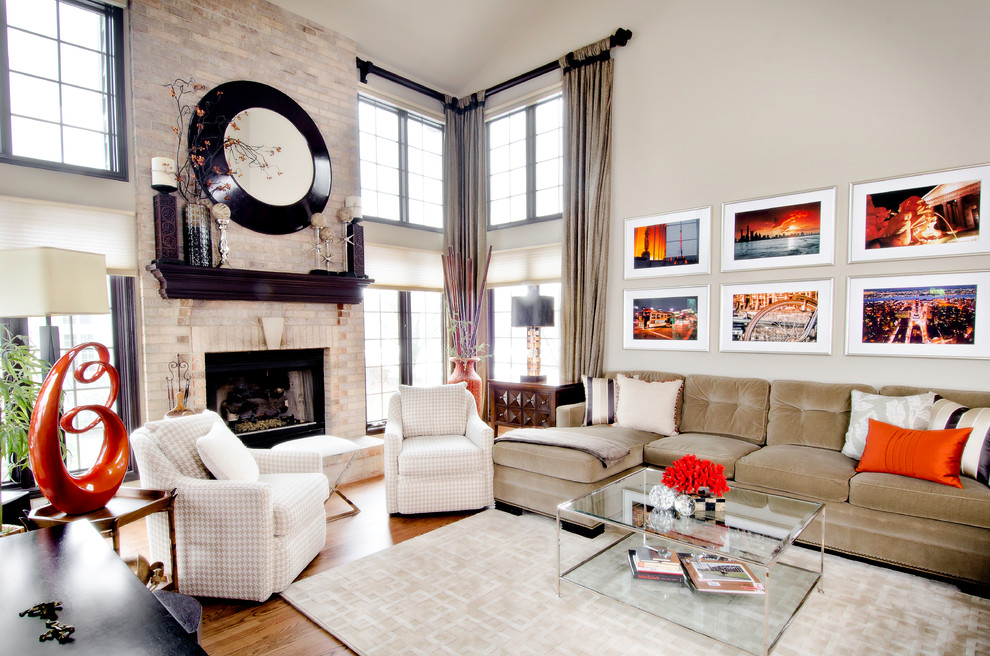This is an example of a large transitional living room in Chicago with beige walls, medium hardwood floors, a standard fireplace and a brick fireplace surround.