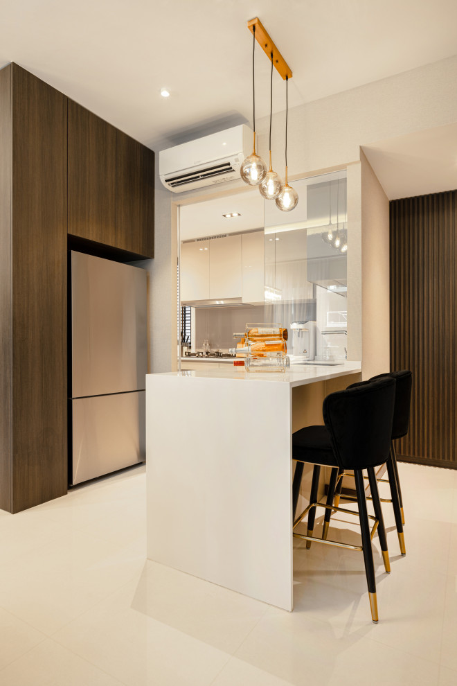 Photo of a mid-sized contemporary u-shaped kitchen in Singapore with white cabinets, mirror splashback, stainless steel appliances, a peninsula, beige floor and white benchtop.