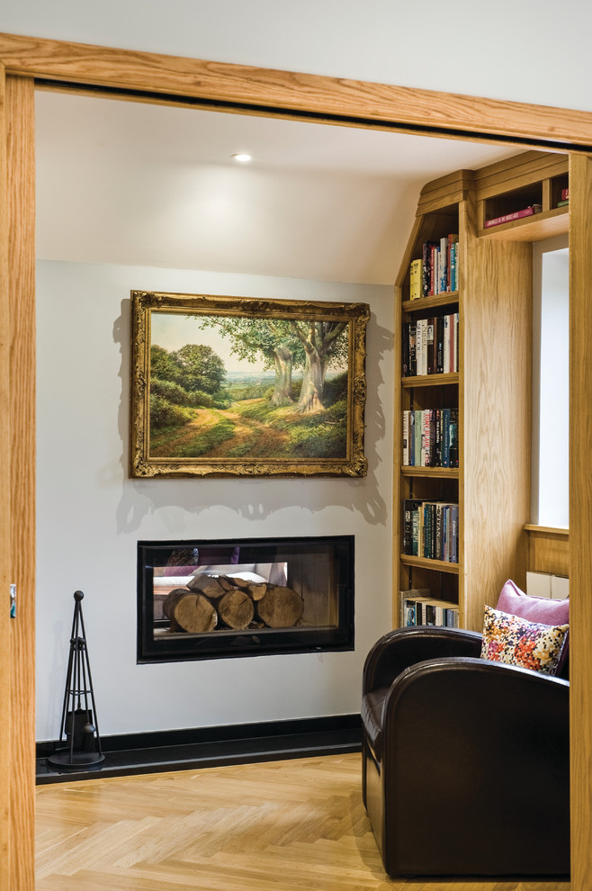 Inspiration for a small contemporary open plan living room in West Midlands with a reading nook, beige walls, a standard fireplace, a plastered fireplace surround, no tv and brown floors.