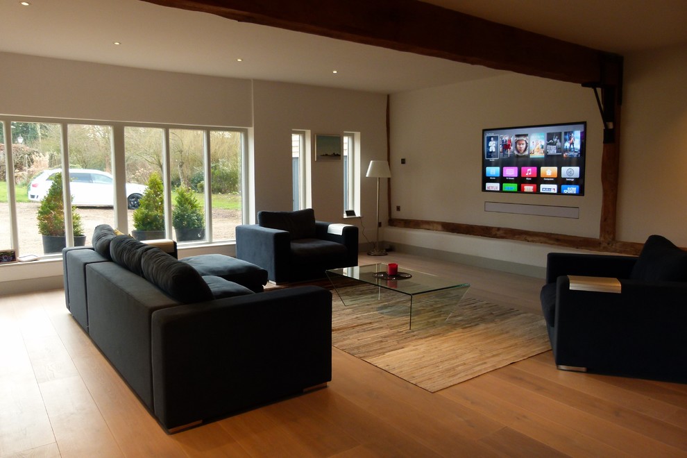 Design ideas for a country home theatre in Kent with light hardwood floors and a built-in media wall.