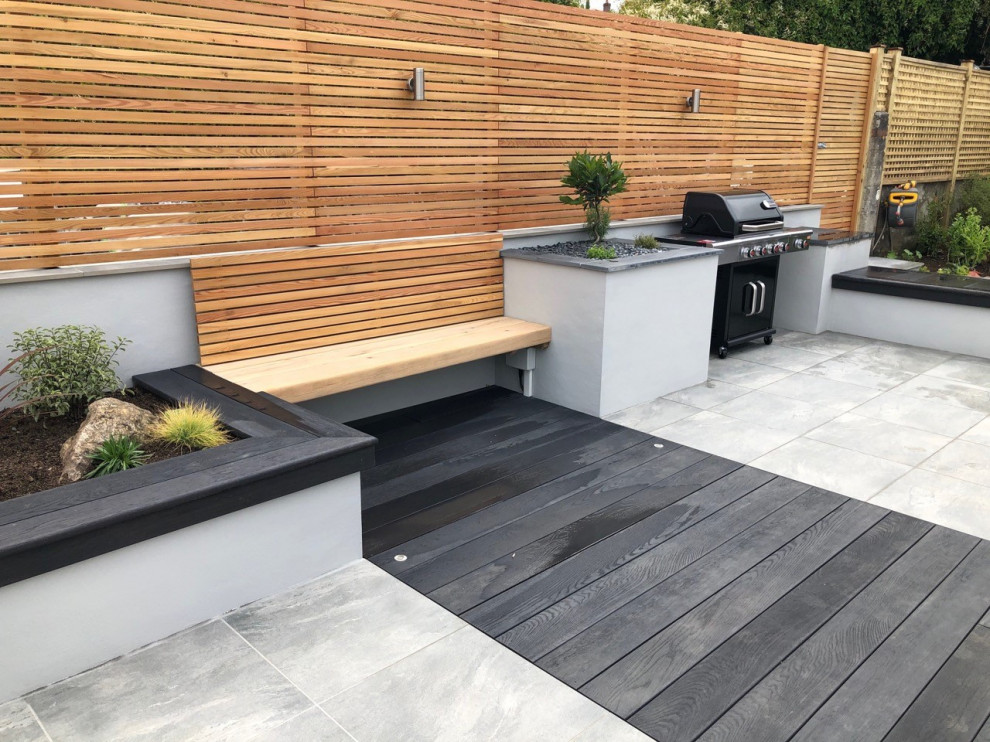 This is an example of a mid-sized modern backyard patio in Cornwall with an outdoor kitchen and decking.