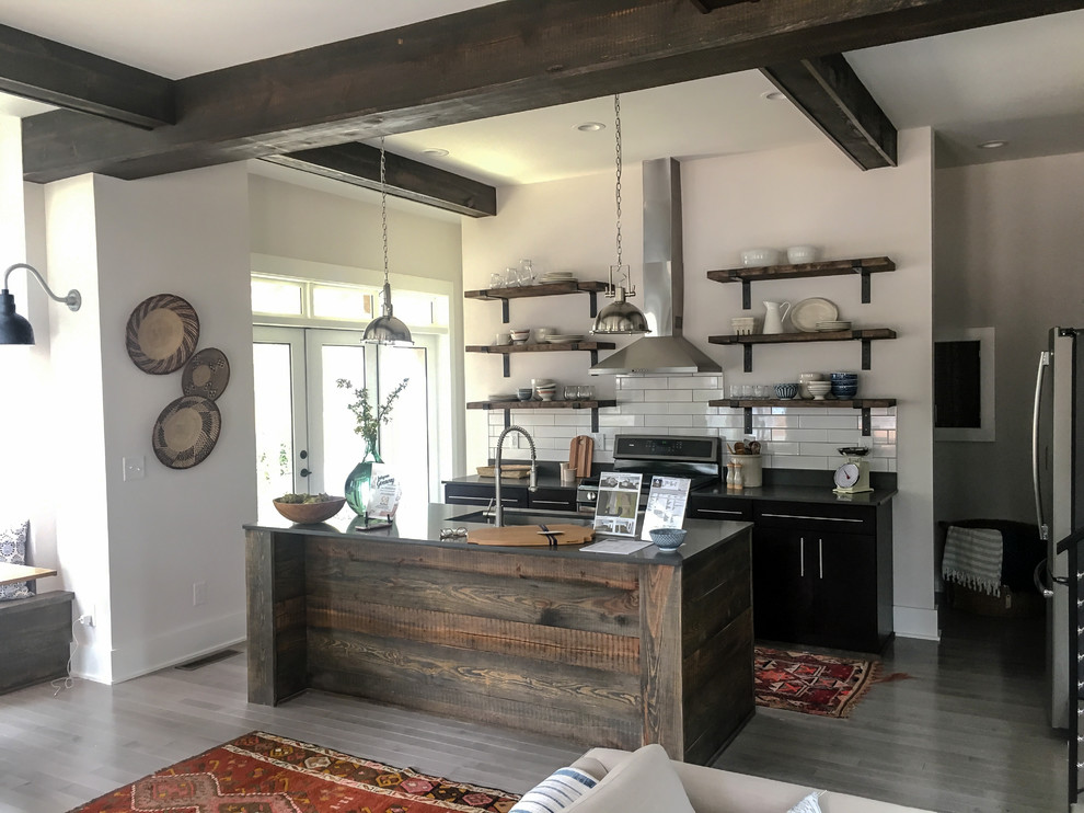 Inspiration for a small country single-wall eat-in kitchen in Raleigh with an undermount sink, open cabinets, black cabinets, quartz benchtops, white splashback, ceramic splashback, black appliances, medium hardwood floors and with island.