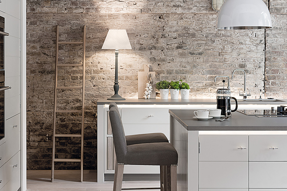 Inspiration for a large contemporary l-shaped open plan kitchen in Nantes with an undermount sink, flat-panel cabinets, grey cabinets, brown splashback, brick splashback, black appliances, light hardwood floors, with island and beige floor.