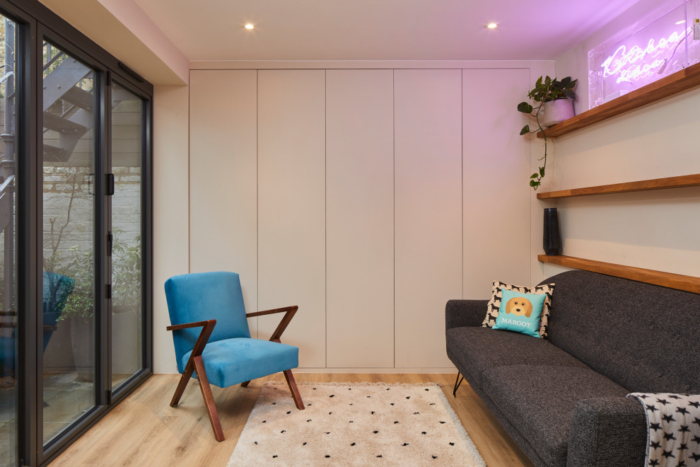 Источник вдохновения для домашнего уюта: маленькая открытая гостиная комната в современном стиле с белыми стенами, паркетным полом среднего тона, коричневым полом и синим диваном без камина, телевизора для на участке и в саду