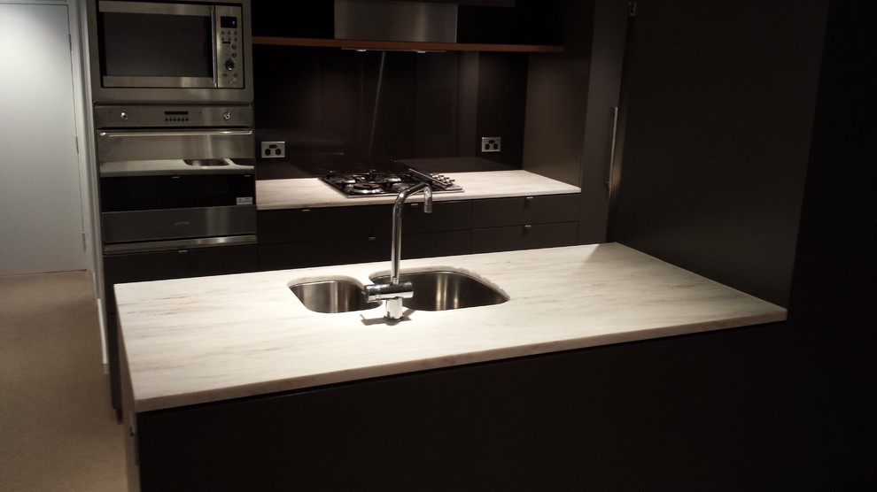This is an example of a mid-sized contemporary kitchen in Melbourne with solid surface benchtops.