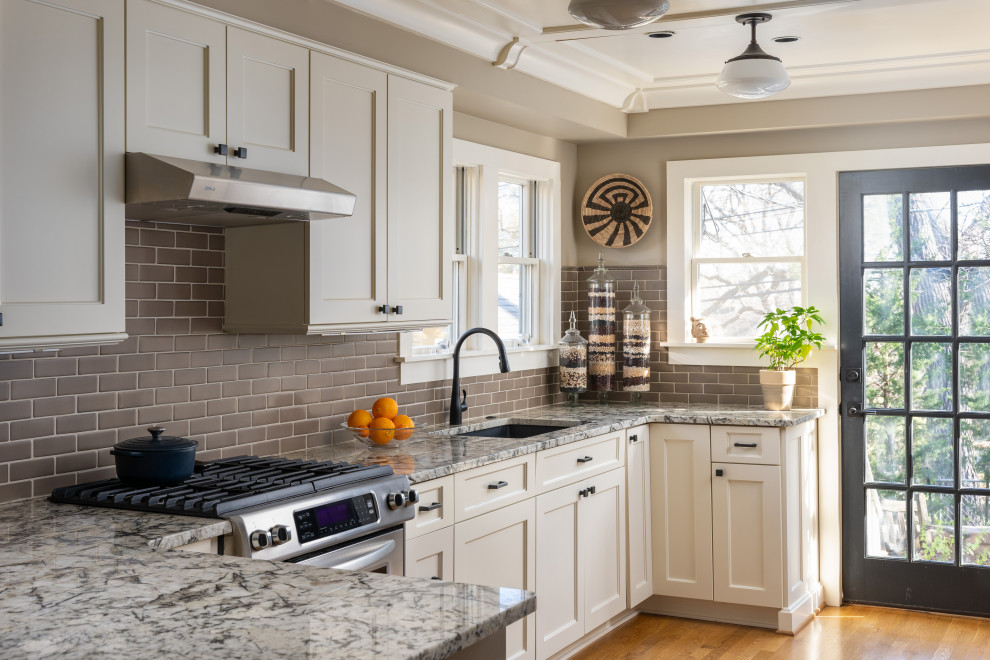 Design ideas for a small transitional u-shaped eat-in kitchen in Kansas City with an undermount sink, shaker cabinets, white cabinets, granite benchtops, brown splashback, ceramic splashback, stainless steel appliances, medium hardwood floors, a peninsula and wood.
