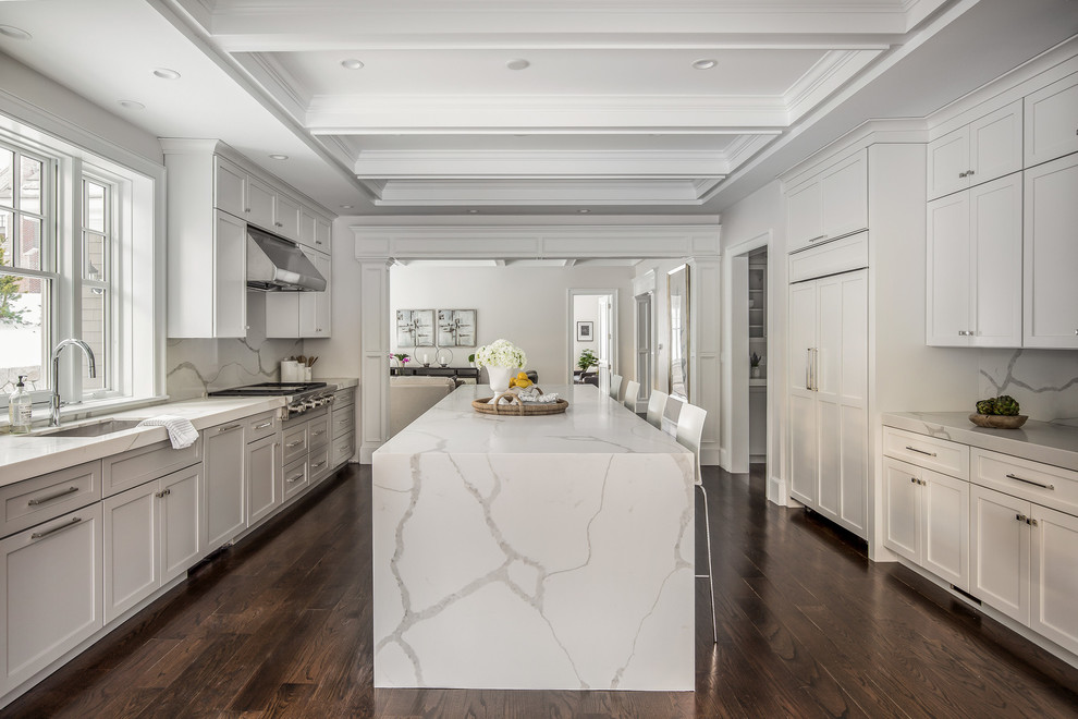 Large transitional galley dark wood floor eat-in kitchen photo with an undermount sink, shaker cabinets, white cabinets, quartz countertops, stone slab backsplash, paneled appliances and an island