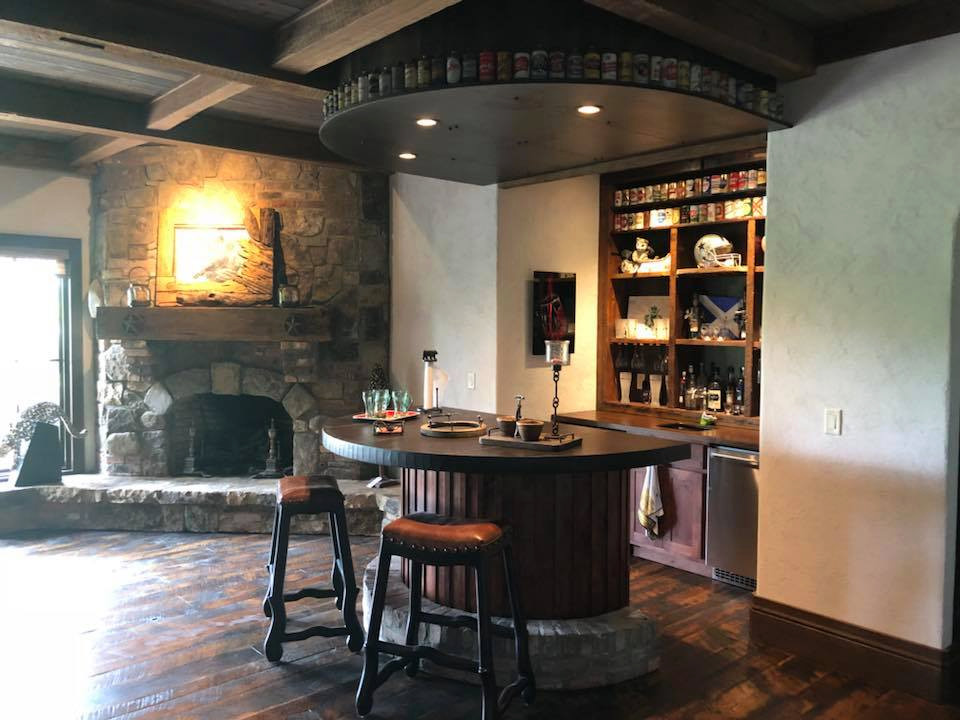 Inspiration for a large traditional home bar in Other with raised-panel cabinets, dark wood cabinets, wood benchtops and brown benchtop.