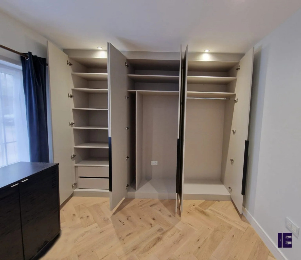 Foto på en stor funkis garderob, med släta luckor, grå skåp, plywoodgolv och brunt golv