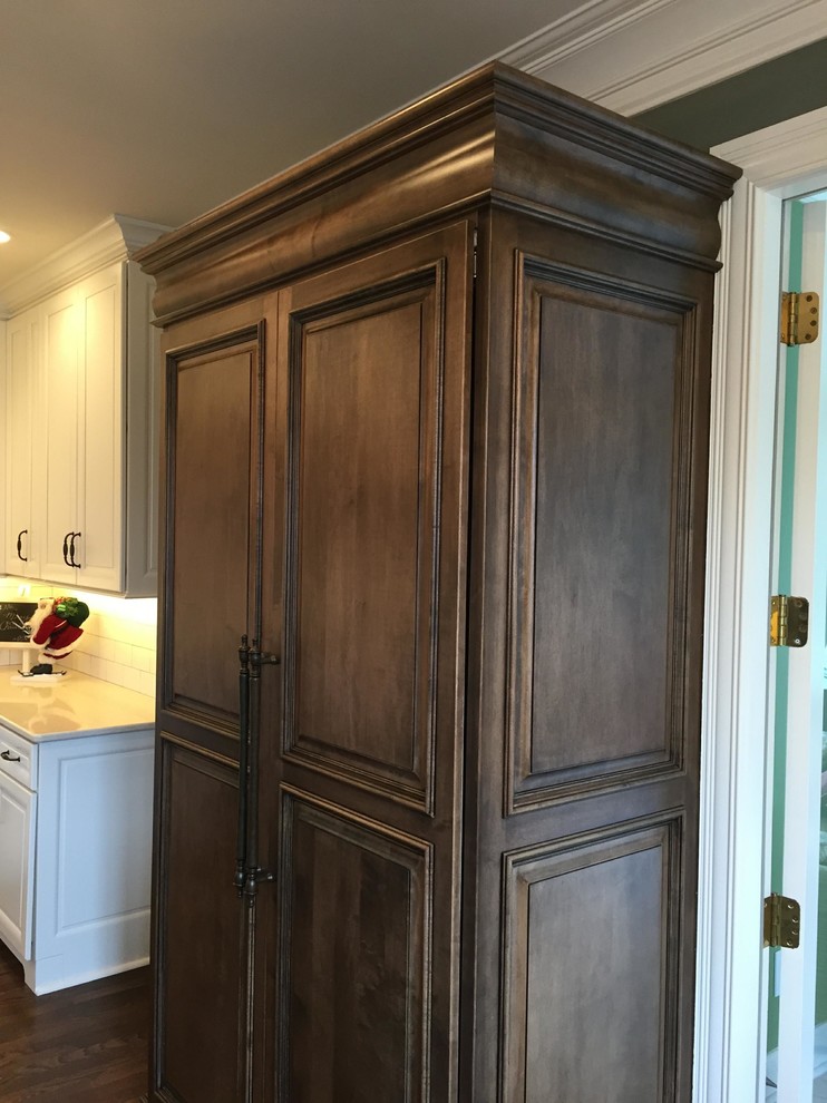 Example of a large transitional u-shaped dark wood floor eat-in kitchen design in Indianapolis with an undermount sink, raised-panel cabinets, white cabinets, granite countertops, white backsplash, subway tile backsplash, stainless steel appliances and an island