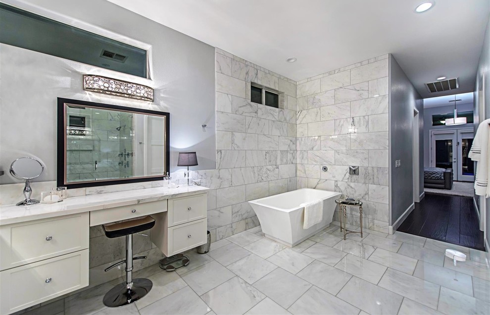 Inspiration for an expansive contemporary master bathroom in Las Vegas with shaker cabinets, white cabinets, a freestanding tub, an alcove shower, gray tile, white tile, stone tile, grey walls, marble floors, an undermount sink and granite benchtops.