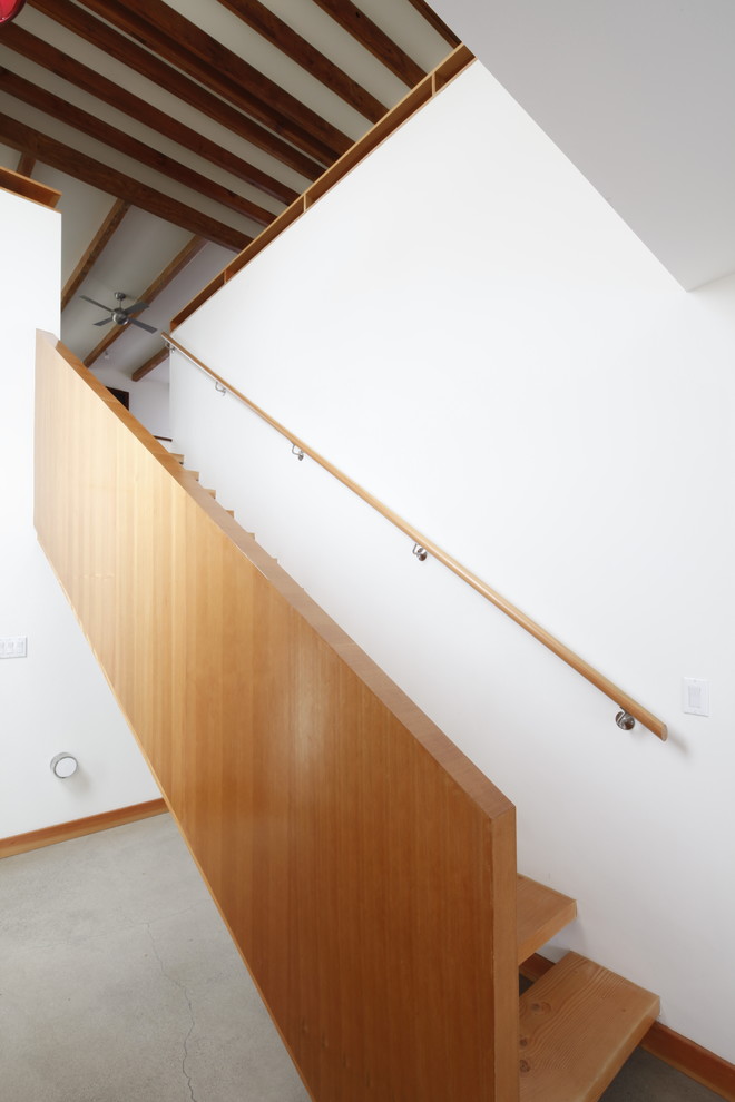 Photo of a mid-sized contemporary wood straight staircase in Los Angeles with open risers and wood railing.