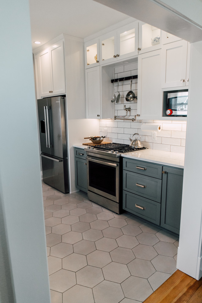 Inspiration for a small country galley separate kitchen in Seattle with a farmhouse sink, shaker cabinets, grey cabinets, quartz benchtops, white splashback, ceramic splashback, stainless steel appliances, porcelain floors, grey floor and white benchtop.