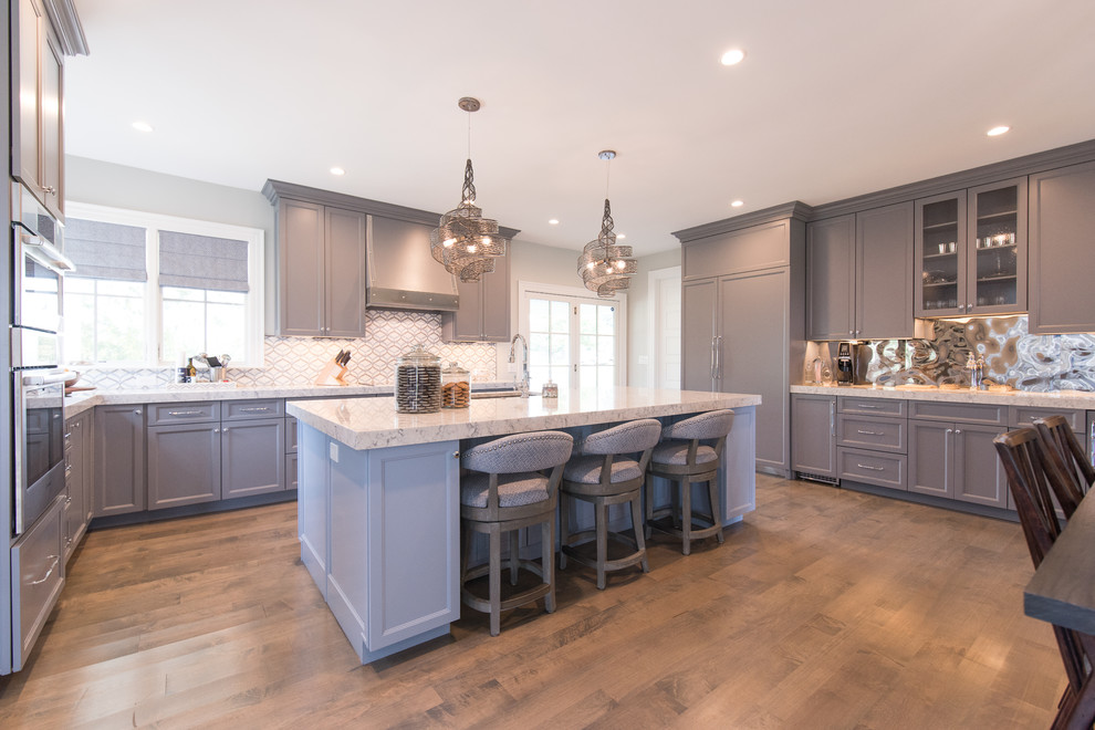 Large transitional medium tone wood floor eat-in kitchen photo with a single-bowl sink, shaker cabinets, gray cabinets, quartz countertops, multicolored backsplash, mirror backsplash and paneled appliances