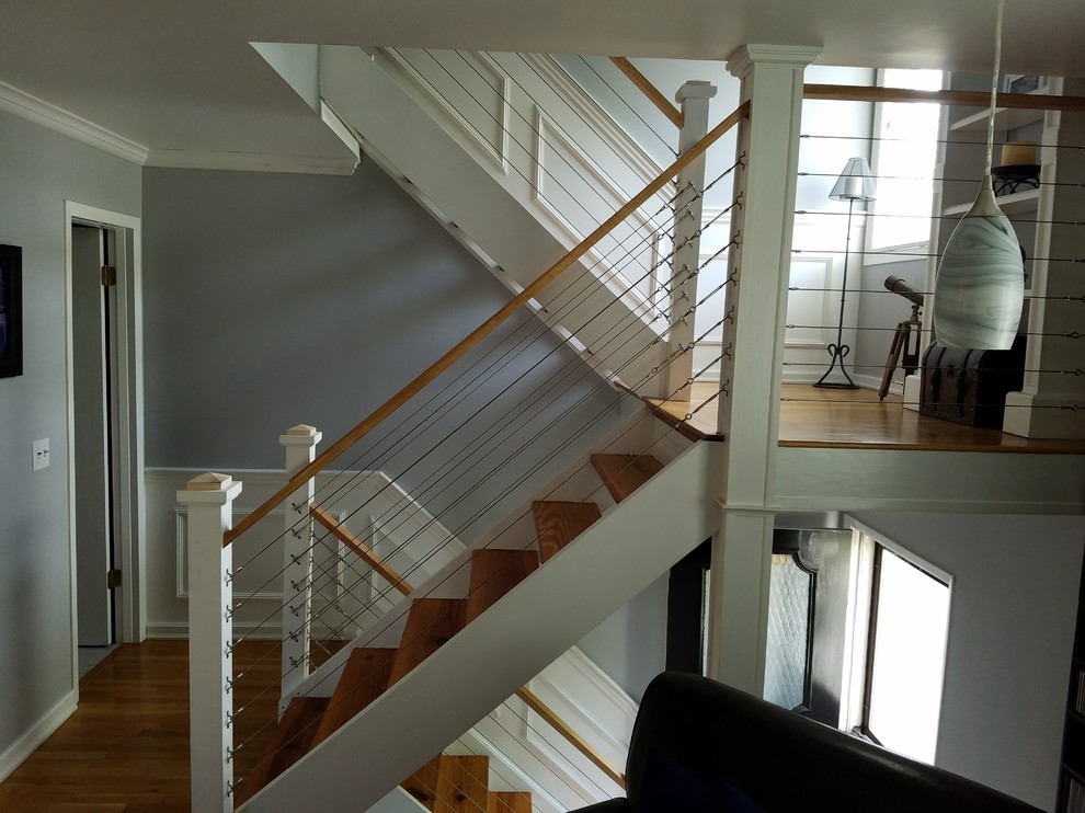 Design ideas for a transitional wood u-shaped staircase in New York with open risers and wood railing.