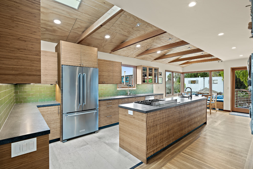 This is an example of a large contemporary l-shaped eat-in kitchen in San Francisco with an undermount sink, flat-panel cabinets, medium wood cabinets, quartz benchtops, green splashback, ceramic splashback, stainless steel appliances, porcelain floors, with island, grey floor and black benchtop.