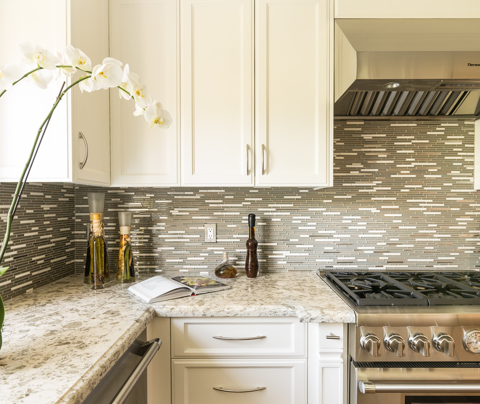 Example of a mid-sized transitional u-shaped dark wood floor eat-in kitchen design in Los Angeles with an undermount sink, raised-panel cabinets, white cabinets, granite countertops, gray backsplash, matchstick tile backsplash and stainless steel appliances