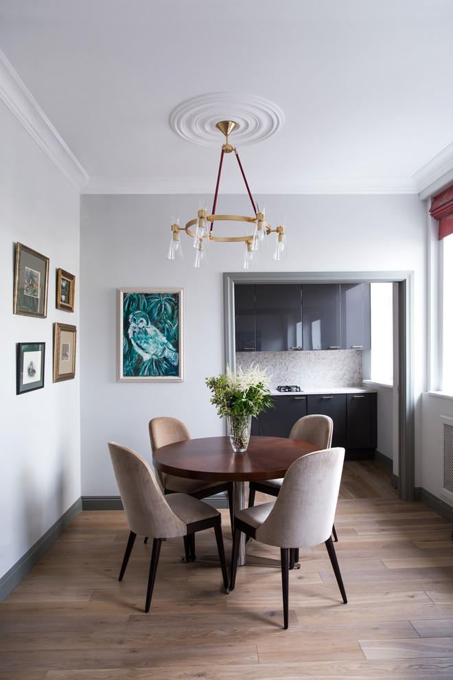 Photo of a small contemporary dining room in Moscow with grey walls and light hardwood floors.