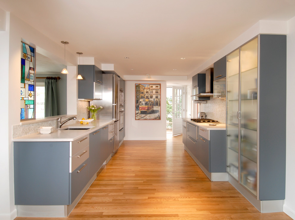 This is an example of a contemporary eat-in kitchen in Boston with an undermount sink, flat-panel cabinets, blue cabinets and stainless steel appliances.